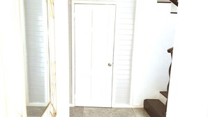 A staircase with a wooden handrail and a white door at the top. - The Best of Home - Tranquil, Comfort & Convenient (Beausejour)