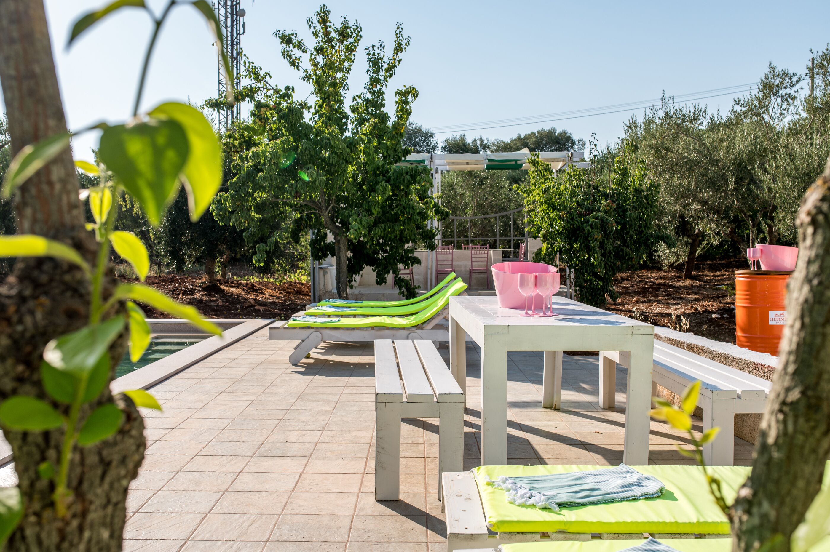 An outdoor patio area with a table, benches, and lounge chairs.