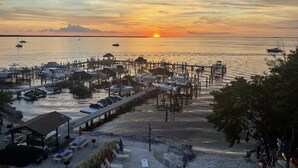 A marina with boats docked, a pier extending into the water, and a sunset in the background. - Paradise Moon Bay! (Key Largo)