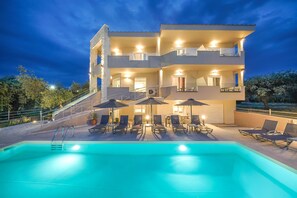 Un hôtel à plusieurs étages doté d’une piscine, d’un espace extérieur aménagé et d’un escalier menant aux étages supérieurs.
