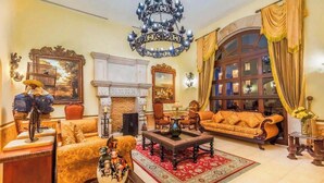 A spacious living room with a fireplace, a large chandelier, and a comfortable sofa set. - Astonishing Studio at Cabo San Lucas (Cabo San Lucas)