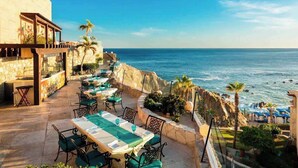 An outdoor dining area with tables and chairs, overlooking the sea. - Astonishing Studio at Cabo San Lucas (Cabo San Lucas)