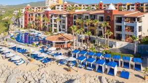 A resort with a swimming pool, multiple balconies, and a beach area with sun loungers. - Astonishing Studio at Cabo San Lucas (Cabo San Lucas)