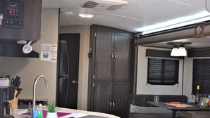 A compact RV kitchen with a sink, countertop, and cabinets. - Grand Canyon RV Glamping Luxury Suite (Glamping Getaway) (Williams)