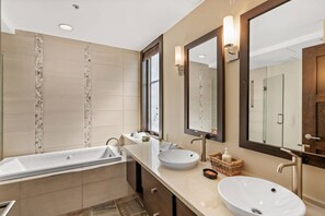 A modern bathroom with a large bathtub, a sink, and a mirror. - Hayden Lodge by iTrip Aspen Snowmass (Snowmass Village)