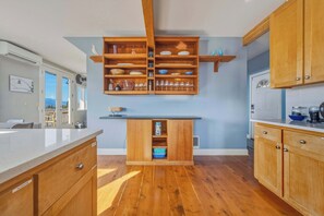 Een moderne keuken met houten kastjes, een centraal eiland en inbouwkasten erboven.