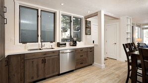 Una cocina moderna con armarios de madera, lavavajillas y cafetera.