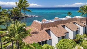 A hotel with multiple buildings, a clear view of the ocean, and palm trees. - Ocean Views and Lots of Turtles - 2 bedroom in Napili (Napili)