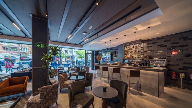 Un moderno bar con asientos y vistas a la calle.