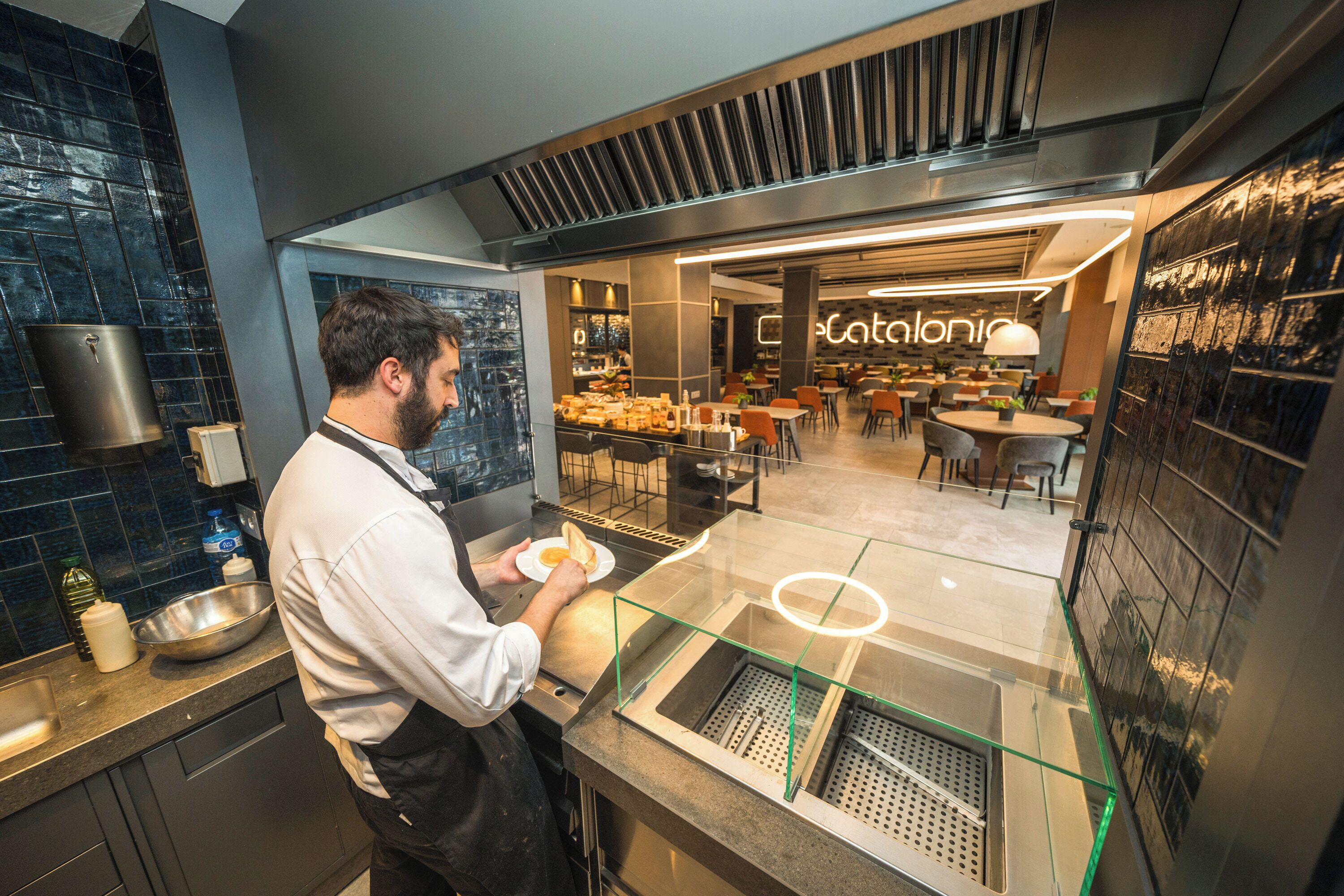 Una cocina moderna con un mostrador de vidrio y una zona de comedor a lo lejos.