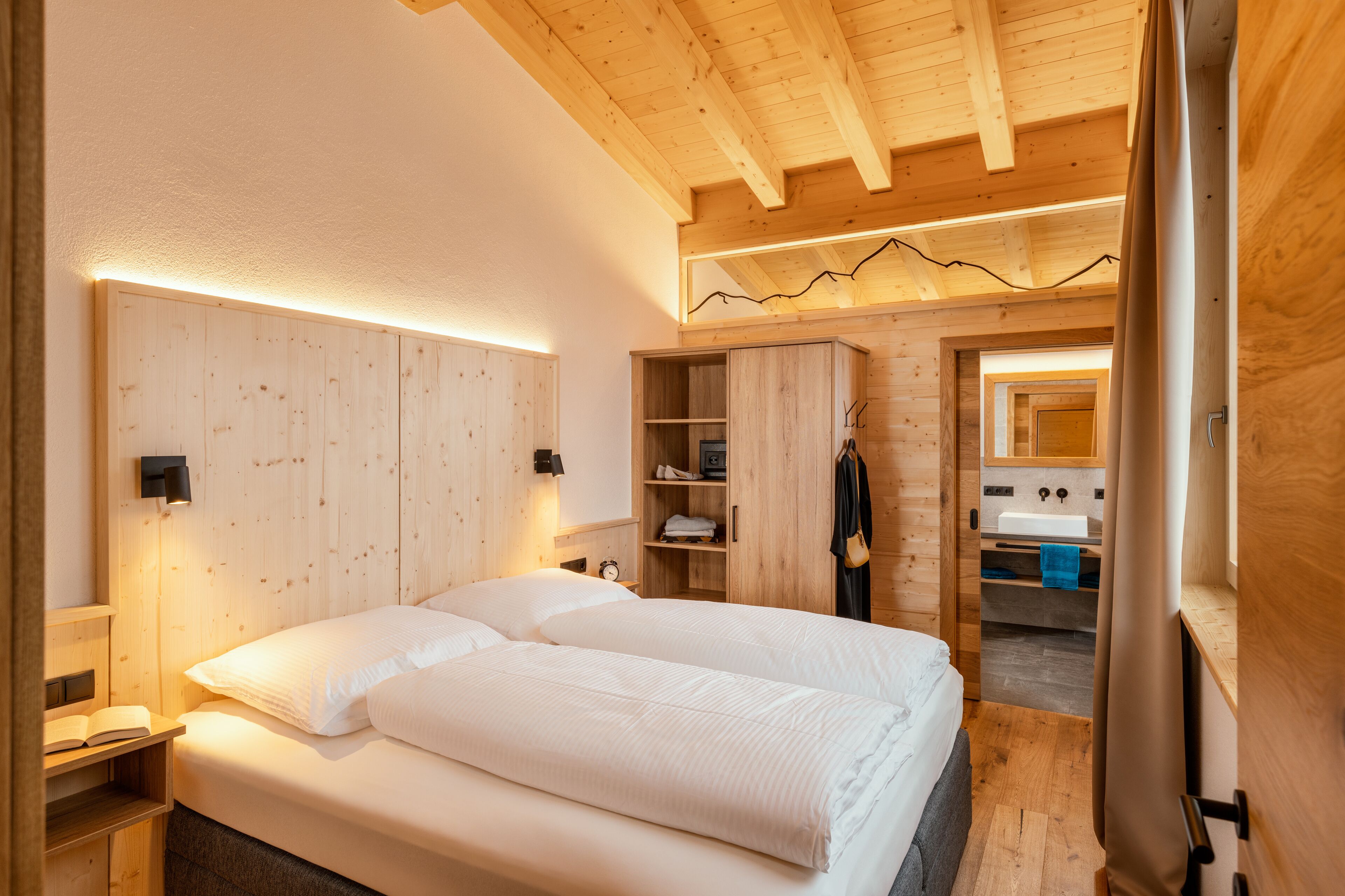 Ein Schlafzimmer aus Holz mit Bett, Nachttischen und einem Kleiderschrank.