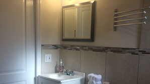 A bathroom with a white sink, a toilet, and a mirror above the sink. - Chic and Comfortable Studio Free Street Parking (Miami)