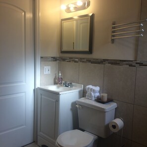 A bathroom with a white sink, a toilet, and a mirror above the sink.