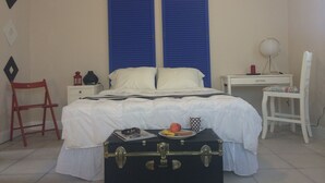 A bedroom with a bed, a suitcase, a chair, a desk, and a lamp. - Chic and Comfortable Studio Free Street Parking (Miami)