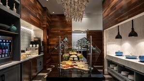 A modern kitchen with a central buffet display, wooden paneling, and a hanging light fixture. - BREATHTAKING VIEWS - RITZ CARLTON ST. THOMAS (St Thomas)