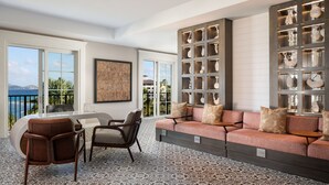 A spacious living room with a large sofa, two armchairs, and a dining table. There is a view of the sea through large windows. - BREATHTAKING VIEWS - RITZ CARLTON ST. THOMAS (St Thomas)