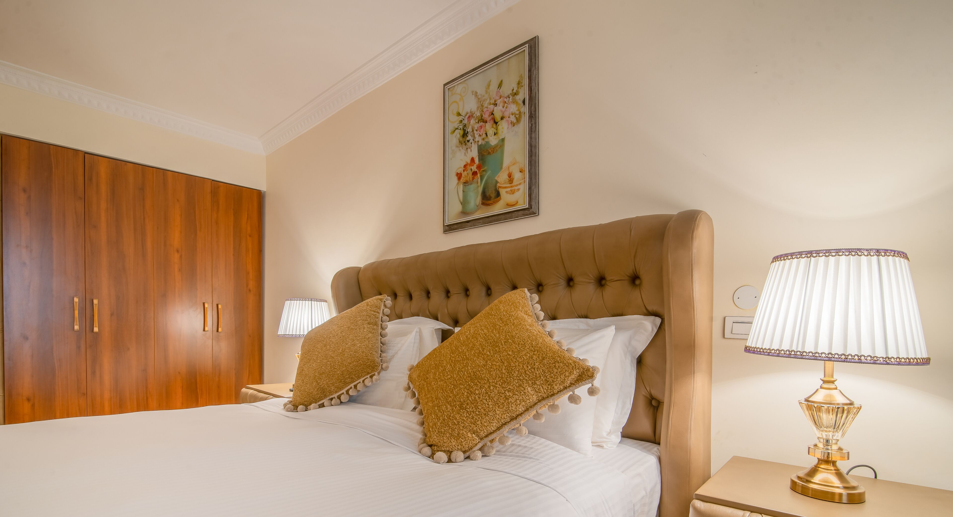 Un dormitorio con una cama grande, un armario de madera y una lámpara decorativa.