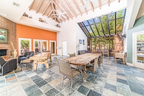 Relax in this inviting space with a large dining table, comfortable seating, and a cozy fireplace.