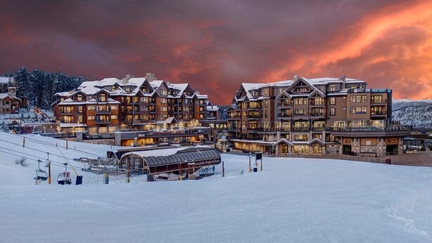 A large, multi-story hotel with a ski lift in the foreground, surrounded by snow-covered terrain and mountains in the background. - Grand Colorado Peak 8 (Breckenridge)