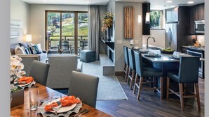 A modern hotel room with a dining area, kitchen, and a balcony with a view. - Grand Colorado Peak 8 (Breckenridge)