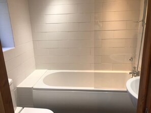 Une salle de bain avec une baignoire, une douche et un lavabo.