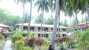 A hotel with multiple floors, surrounded by palm trees and various plants. - Coconhuts Beach Resort-neil Island (Port Blair)