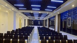 A conference room with rows of chairs, a long table, and a modern ceiling design. - Jinjiang Inn (Xianning Yinquan Avenue) (Xianning)