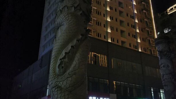 A multi-story building with a large dragon sculpture on the facade. - Jinjiang Inn (Xianning Yinquan Avenue) (Xianning)