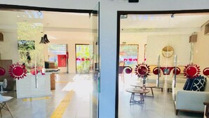 A modern interior with a reception desk, seating area, and glass doors. - Pipa Ubaia Residence Apartments (Tibau do Sul)