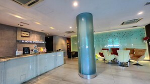A hotel reception area with a modern design, including a reception desk, a large pillar, and seating arrangements. - D North Star Hotel Spa (Sandakan)
