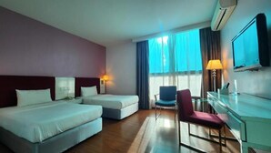 A hotel room with two beds, a desk, a chair, a TV, and a window with curtains. - D North Star Hotel Spa (Sandakan)