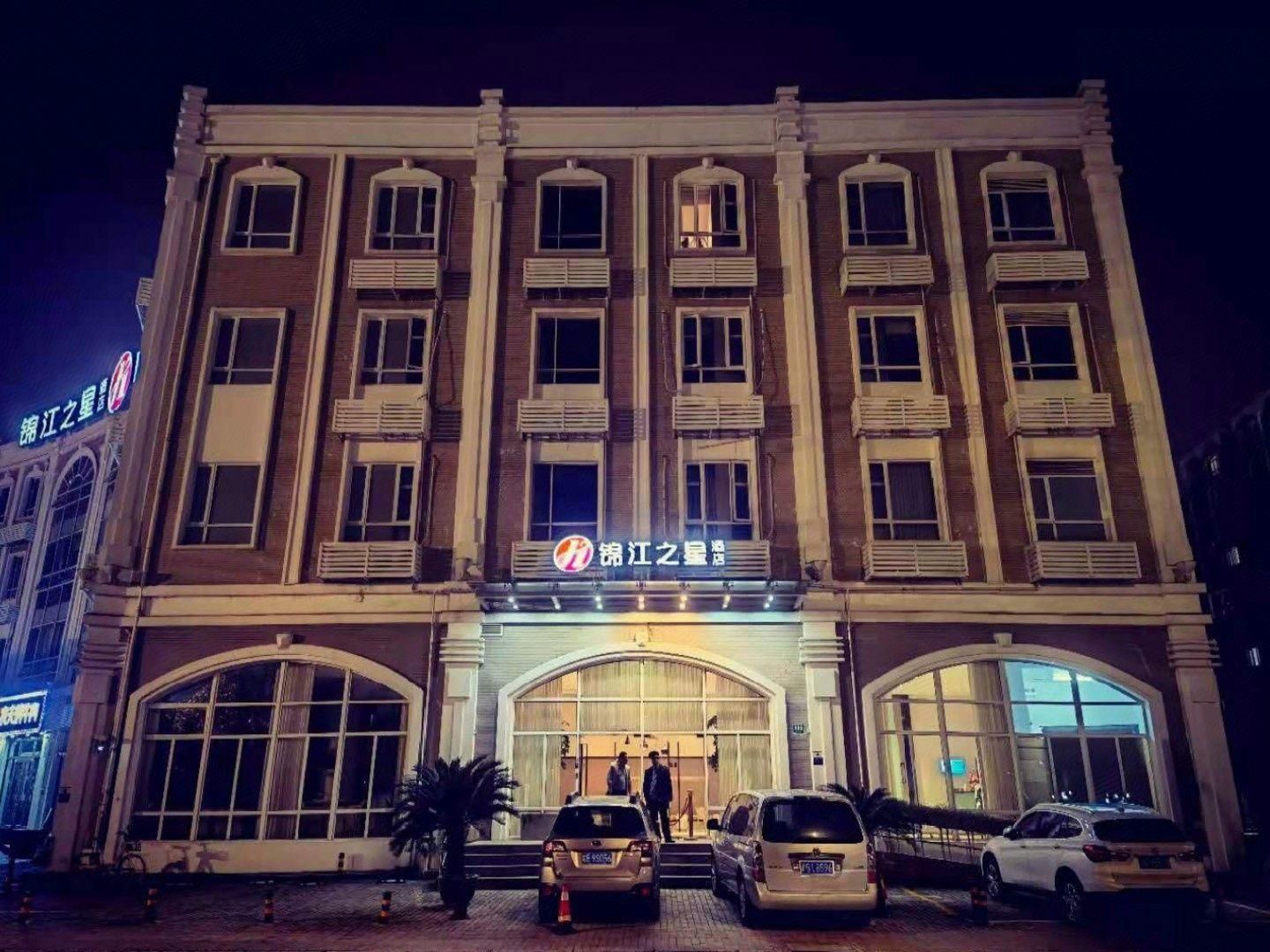 A multi-story hotel with a prominent entrance, large windows, and a sign with non-English characters.