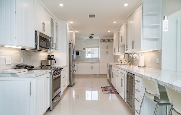 Enjoy cooking in this well-equipped kitchen with a central island, sink, and seating.