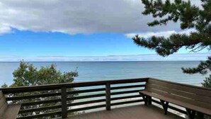 A wooden deck with a railing overlooking a body of water.