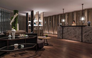A modern lobby with a reception desk, seating area, and decorative elements. - Conrad Hangzhou (Hangzhou)