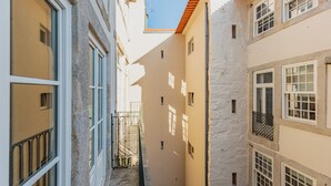 Um beco estreito entre edifícios com varandas e janelas.
