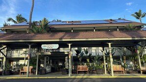 Un edificio con un letrero que dice "Hona Islander Inn" y paneles solares en el techo.
