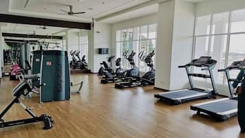 A gym with treadmills, elliptical machines, and weightlifting equipment.