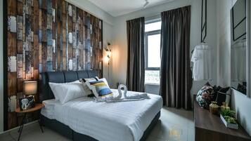 A modern hotel room with a large bed, a wooden wall panel, a window with curtains, a bedside table with a lamp, and a small plant on a dresser.