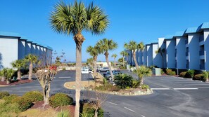 Stylish hotel with modern architecture, surrounded by lush greenery and a parking area.