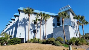 Stunning building with a unique architectural style, surrounded by lush landscaping and palm trees.