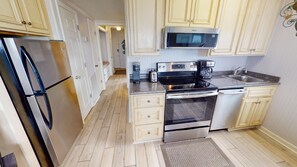 Enjoy cooking in this well-equipped kitchen with a stainless steel refrigerator, microwave, coffee maker, and toaster.