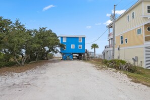 A two-story building with a blue exterior and a yellow one-story building adjacent to it. - Bayfront Vacation Home! (Gulf Shores)