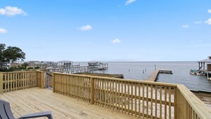 A wooden deck with a view of the water and docks.
