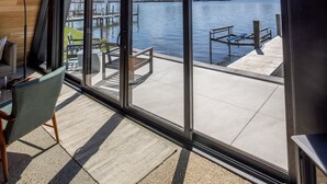 A modern interior with large windows overlooking a waterfront. - Lakewood Lux Property - Saugatuck Harbor Luxury A-Frame, View of Downtown (Saugatuck)
