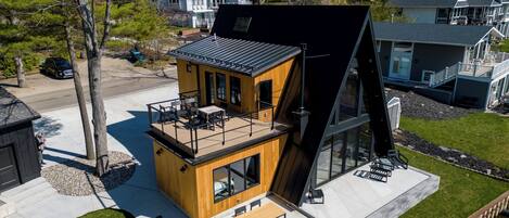 Une maison moderne avec un toit plat, une terrasse et une grande fenêtre.