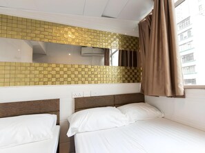 A hotel room with two beds, a tiled wall, an air conditioning unit, and a window with curtains. - Garden Hotel (Kowloon)