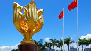 A golden lotus sculpture with two red flags in the background. - Garden Hotel (Kowloon)