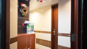 A reception area with a water dispenser, a welcome sign, and a security camera. - Garden Hotel (Kowloon)