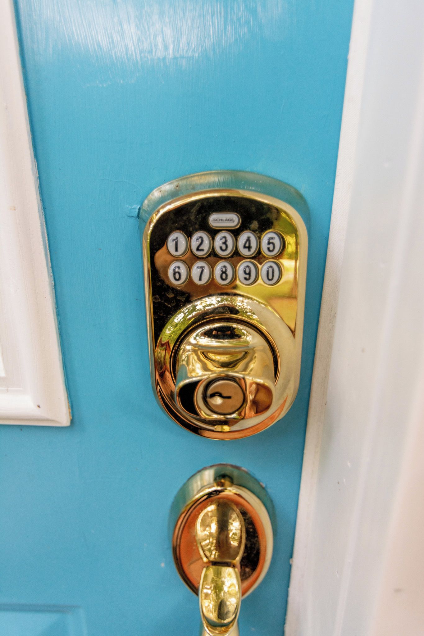 Puerta azul con cerradura de llave dorada y teclado numérico.